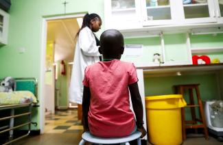 A child sits as a nurse prepares to dispense antiretroviral drugs used to prevent HIV from replicating, at the Nyumbani Children's Home, Nairobi, Kenya, on February 12, 2025.