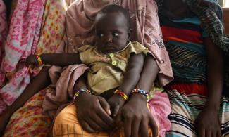 A woman holds her child as they wait to receive treatment in Kobo health center in Kobo village, one of the drought stricken areas of Oromia region, in Ethiopia, April 28, 2016.