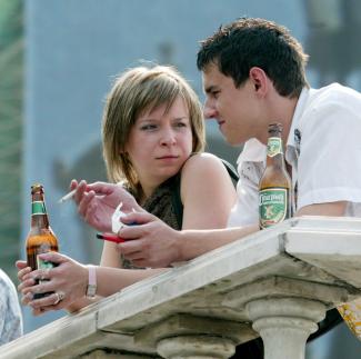 A young couple chats as they drink beer and smoke cigarettes, in Moscow, Russia, on August 8, 2004.
