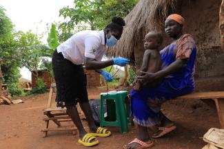 In Uganda’s Bidibidi refugee settlement, a Village Health Team member conducts an in-home health visit to a refugee mother and child. 