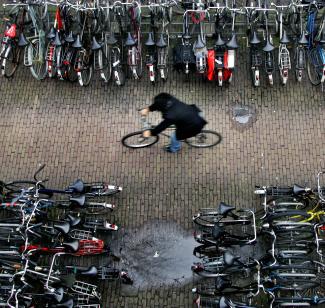 A man rides his bike in a bicycle shed, near Central Station, in Amsterdam, the Netherlands, on January 17, 2007. There are more bicycles than people in the Netherlands.