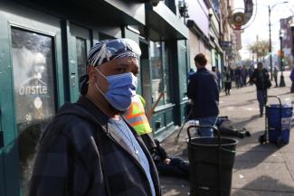 An InSite staff member directs drug users outside the supervised injection site on Hastings Street, in Vancouver, British Columbia, Canada, on March 25, 2020. 