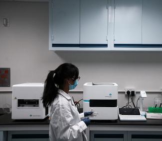 A staff member walks past the machines used for pathogen detection, at a laboratory inside the Emerging Viral Diagnostics office, in Hong Kong, China, on March 13, 2023.