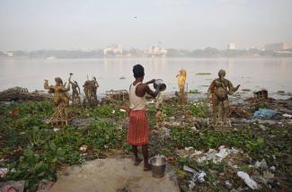 A man pours water on the polluted banks of river Ganges, in Kolkata, India, on October 20, 2010. 