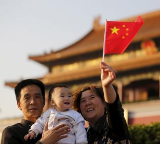 A baby and his grandparents take their souvenir picture in front of the Tiananmen Gate, in Beijing, China, on November 2, 2015. 