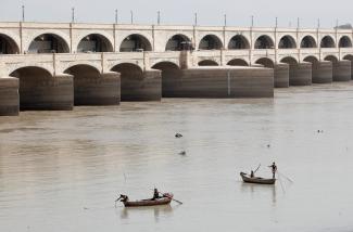 Fishermen row their boats as they catch fish on the Indus River, in Sukkur, Pakistan, on March 19, 2017. 
