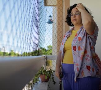 Leticia de Souza Soares, who suffers from pain and health problems caused by long COVID-19, stands on the balcony of her home, in Salvador, Brazil, on December 8, 2023. 