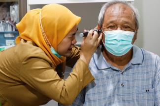 A doctor performs an otoscopy on an elderly man's ear during a free medical check-up, in Jakarta, Indonesia, on February 10, 2025.