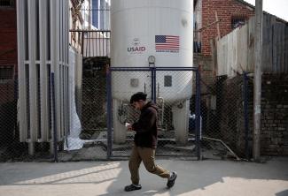 A man walks past the liquid oxygen storage tank installed at Bir Hospital by the United States Agency for International Development, in Kathmandu, Nepal, on February 9, 2025.