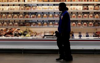 A employee walks by a meat cooler in the grocery section of a Sam's Club, in Bentonville, Arkansas, on June 5, 2014. 