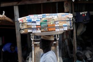 A man selling packets of cigarettes walks through a street, in the old district of Kano, Nigeria, on August 24, 2017.