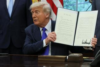 U.S. President Donald Trump shows a signed document as he signs executive orders and proclamations in the Oval Office at the White House, in Washington, D.C., U.S., May 5, 2025.