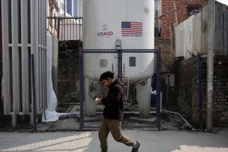 A man walks past the liquid oxygen storage tank installed at Bir Hospital by the United States Agency for International Development, in Kathmandu, Nepal, on February 9, 2025.