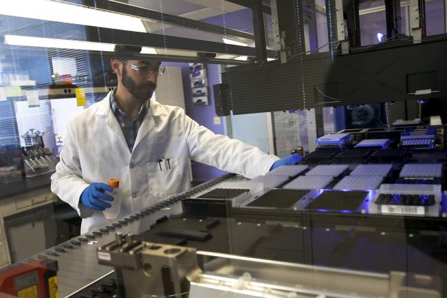 A technician loads a robotic DNA sample automation machine, at a Regeneron Pharmaceuticals Inc. Laboratory, in Tarrytown, New York, on March 24, 2015. 