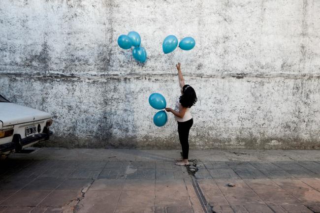 Michell, granddaughter of Rosalia Reyes who was sentenced to eight years in prison after her baby died during a home childbirth, plays with balloons during the welcome party for Rosalia after she was transferred home where she will serve the rest of her time under house arrest