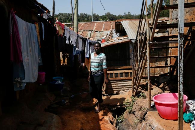 Alice Okwirry, 50, a widow living with HIV/AIDS, walks near her house, in Kianda village, Nairobi, Kenya, on February 28, 2025. 
